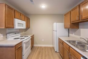 Lancaster apartment for rent - A kitchen with wooden cabinets and white appliances.