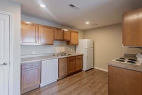 Athens apartment for rent - A kitchen with wooden cabinets and a white refrigerator.