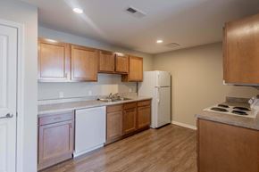 Athens apartment for rent - A kitchen with wooden cabinets and a white refrigerator.