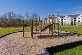 Athens apartment for rent - A playground with a slide and swings in a grassy area.