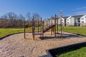 Athens apartment for rent - A playground with a slide and swings in a grassy area.