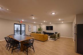 Columbus apartment for rent - A room with a long table and chairs, a couch, a television, and a plant.