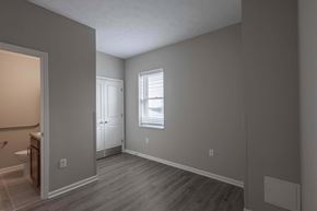 St. Clairsville apartment for rent - A room with a wooden floor and a window with blinds.
