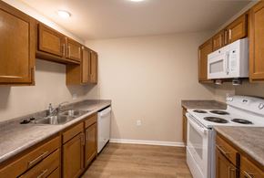 Columbus apartment for rent - A kitchen with wooden cabinets and a white oven.