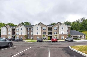 Lancaster apartment for rent - A parking lot in front of a large apartment building with cars parked.
