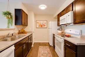 Johnston apartment for rent - a kitchen with white appliances and wooden cabinets