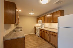 Zanesville apartment for rent - A kitchen with wooden cabinets and a white refrigerator.