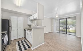 Austin apartment for rent - A kitchen with white cabinets and a black and white checkered rug.