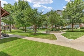 Austin apartment for rent - A green lawn with a building in the background.