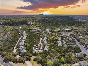 Austin apartment for rent - A sunset view of a residential area with houses and trees.