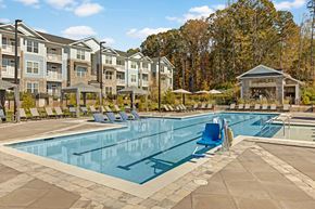 Kannapolis apartment for rent - a swimming pool with chairs around it in front of an apartment building