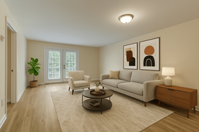 Myrtle Beach apartment for rent - A living room with a grey couch, a chair, a coffee table, and two framed pictures on the wall.