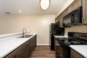 Huntington apartment for rent - a kitchen with black appliances and white counter tops and wood floors
