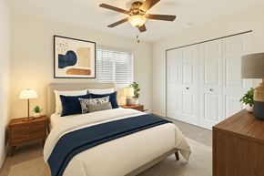 Grand Rapids apartment for rent - A bedroom with a bed, a ceiling fan, and a nightstand with a lamp.