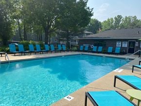 Grand Rapids apartment for rent - A pool with blue chairs and a building in the background.