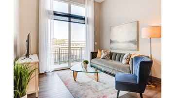 Carmel apartment for rent - A living room with a blue chair and a glass table.