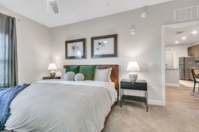 Cartersville apartment for rent - A bedroom with a large bed and two framed pictures on the wall.