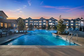 Cartersville apartment for rent - A swimming pool in front of apartment buildings at dusk.