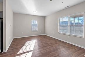 Fort Wayne triplex for rent - A room with wooden floors and a window with blinds.