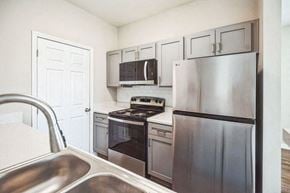 Fort Wayne triplex for rent - A kitchen with a stainless steel refrigerator, oven, and microwave.