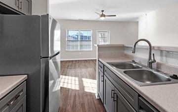 Fort Wayne triplex for rent - A kitchen with a refrigerator, sinks, and a ceiling fan.