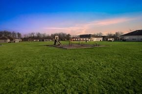 Fort Wayne triplex for rent - A playground with a swing set and a slide in the middle of a grassy field.