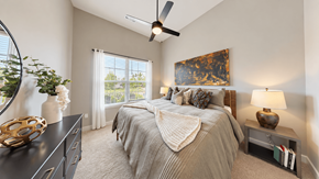 Mcdonough apartment for rent - Furnished A2 apartment bedroom with layered bedding, bedside lamps, and a dresser at Argento at the Bridges in McDonough, GA.