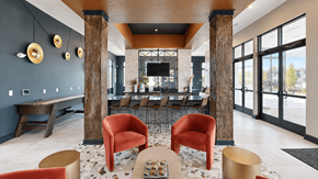 Mcdonough apartment for rent - Clubhouse bar seating, television, and shuffleboard table at Argento at the Bridges in McDonough, GA.