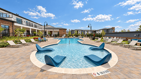 Mcdonough apartment for rent - Shallow pool sun shelf with four blue in-water loungers at Argento at the Bridges in McDonough, GA.