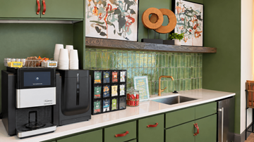 Gallatin apartment for rent - A kitchen with green cabinets and a black coffee maker.