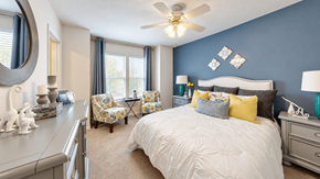 Myrtle Beach apartment for rent - Furnished bedroom with a white upholstered headboard, blue accent wall and window seating at Canterbury Apartments in Myrtle Beach, SC.