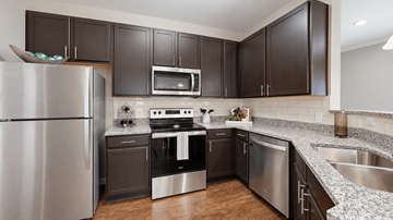Indian Land apartment for rent - A modern kitchen with dark brown cabinets and stainless steel appliances.