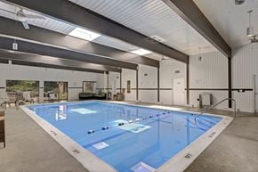 Grand Rapids apartment for rent - a large indoor swimming pool in a white building with a ceiling with skylights