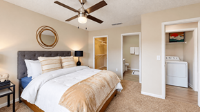 Cartersville apartment for rent - Furnished bedroom with a ceiling fan, walk-in closet opening, and nearby bathroom at Icon Cartersville Apartments.