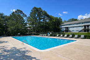 Birmingham townhouse for rent - A large swimming pool surrounded by trees and lounge chairs.