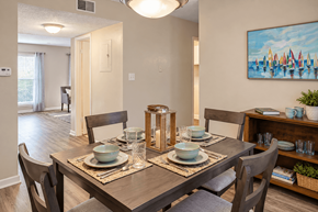 Birmingham townhouse for rent - Dining area with wood-style flooring and space for a four-person table at Madison Park Apartments & Townhomes in Birmingham, AL.