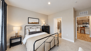 Cartersville apartment for rent - Furnished apartment bedroom with metal bed frame, dresser and adjoining bathroom at The View on Canton in Cartersville, GA.