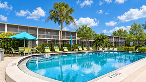 Largo apartment for rent - Swimming pool with lounge chairs, turquoise umbrellas and palm trees at Waterchase Apartments in Largo, FL.