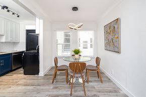 Los Angeles apartment for rent - a dining room with a glass table and chairs and a kitchen with a black refrigerator