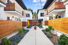 Los Angeles apartment for rent - A modern residential area with a central walkway and houses on either side.