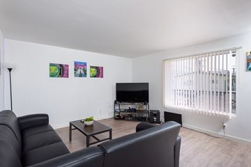 Long Beach apartment for rent - a living room with a black leather couch and a television