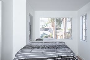 Long Beach apartment for rent - A bedroom with a bed and a window with blinds.