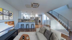 Los Angeles apartment for rent - A modern living room with a staircase leading to the upper level.