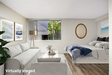 Venice apartment for rent - A living room with a grey couch and a white bed.