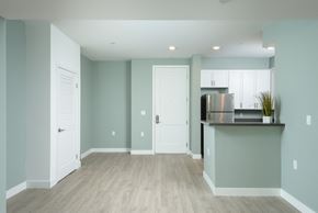 Reseda apartment for rent - an empty living room with a kitchen and a door