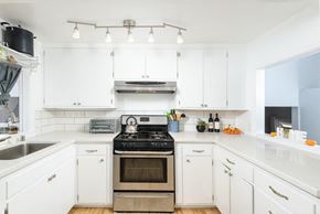 Long Beach apartment for rent - A modern kitchen with white cabinets and a stainless steel oven.