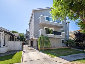 Long Beach apartment for rent - A modern two-story house with a white fence and a driveway.