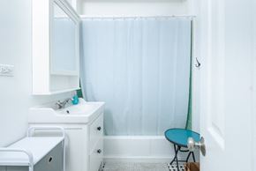Long Beach apartment for rent - A small bathroom with a white sink and a blue chair.