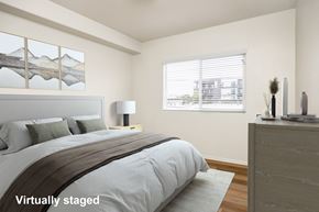 Los Angeles apartment for rent - A bedroom with a large bed and a window with blinds.