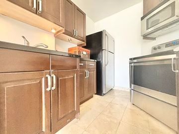 Los Angeles apartment for rent - A kitchen with brown cabinets and a black refrigerator.
